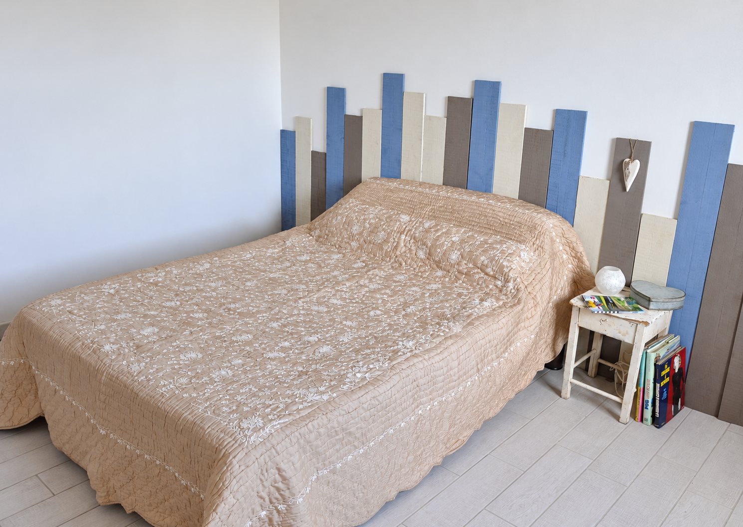 Chambre avec tête de lit en planches de bois bleues, crème et taupe